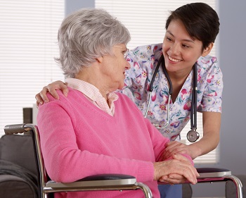 Domestic nurse talking with Older patient in wheelchair